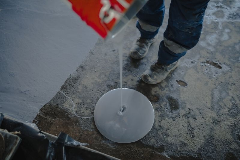 Epoxy mixture being poured onto a Hobart floor during installation