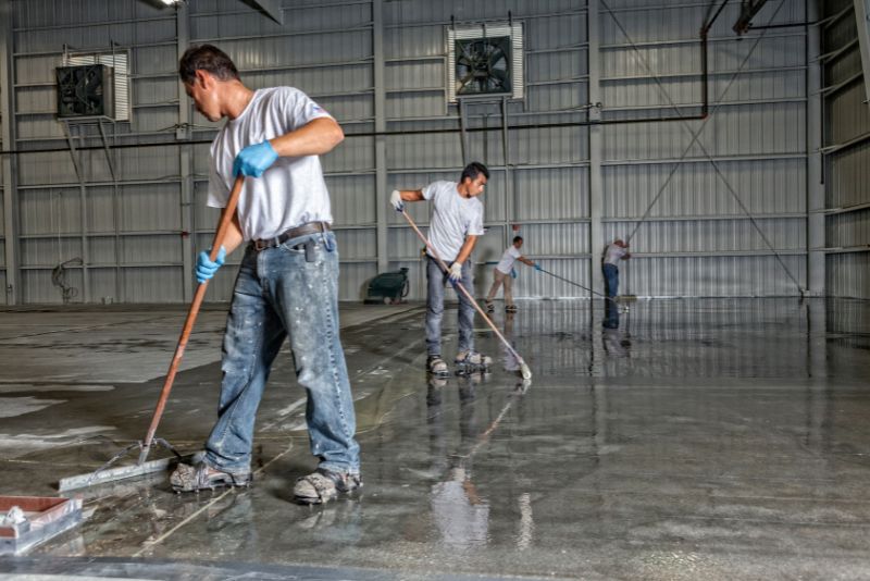workers installing an epoxy overlay in a warehouse