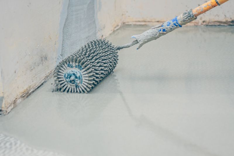 Close-up of a brush applying an epoxy floor coating during installation